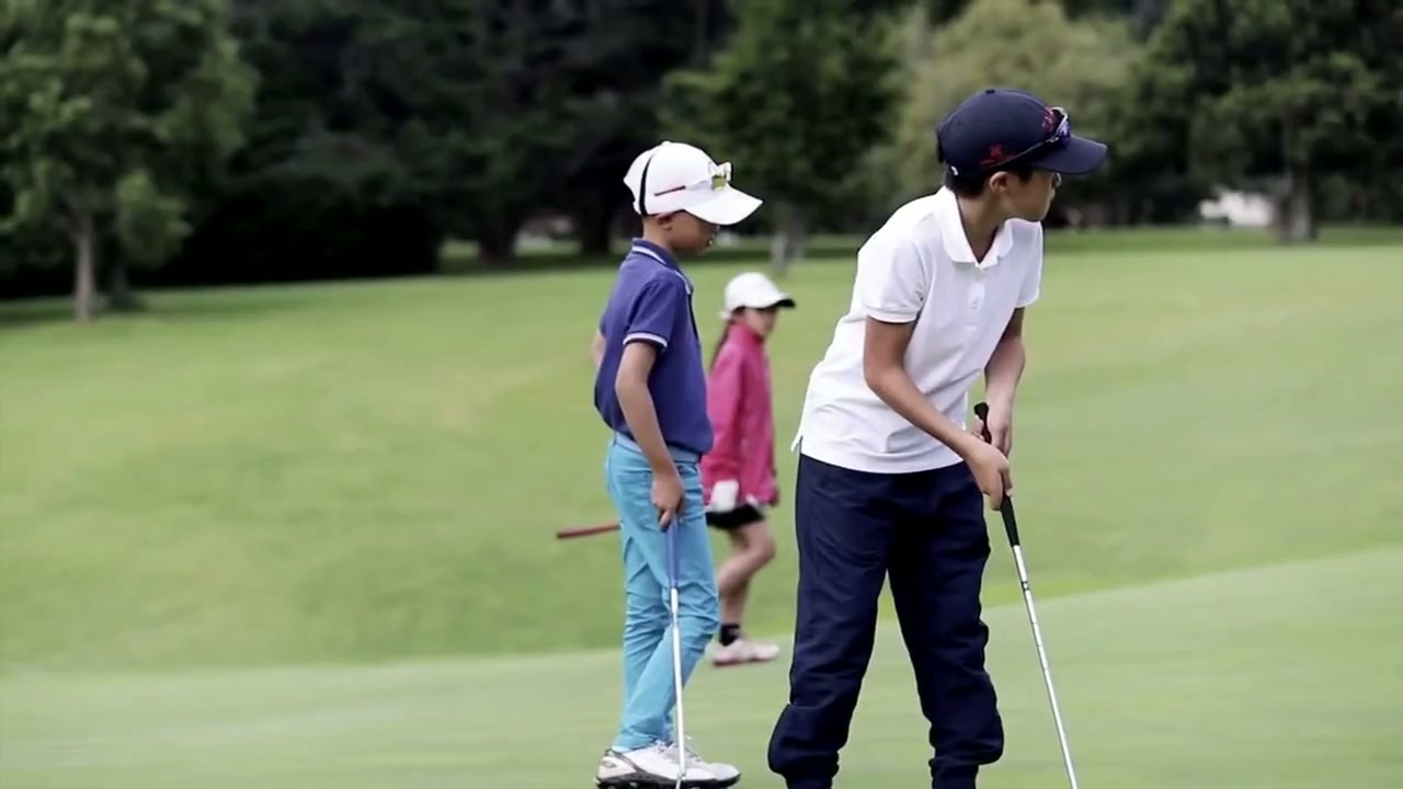 Coach and player reviewing putting data beside an indoor green