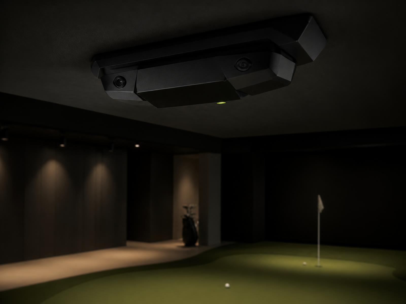 Ceiling-mounted Puttlogix camera unit above a putting green