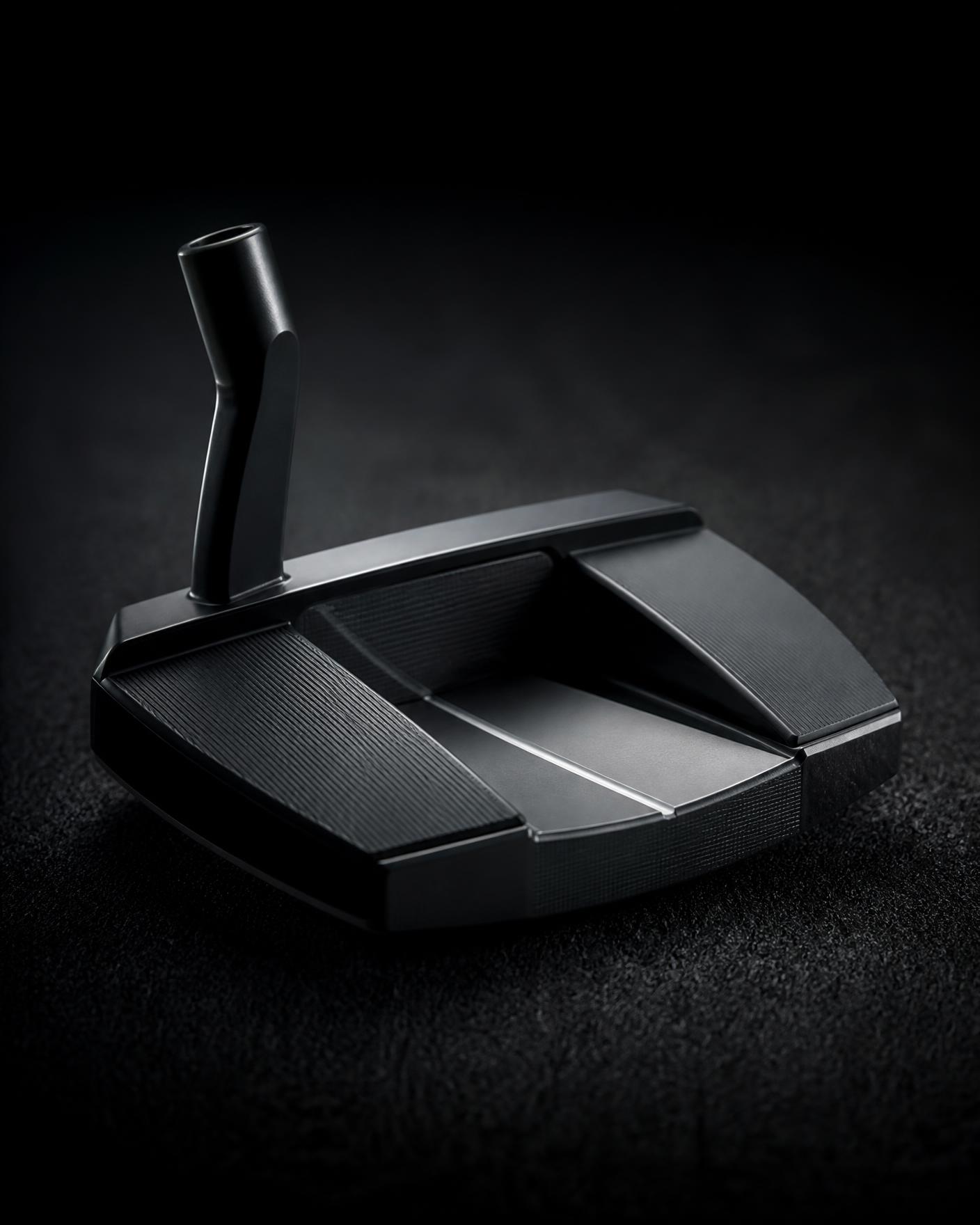 Mallet putter head on a dark green with nothing attached to the club