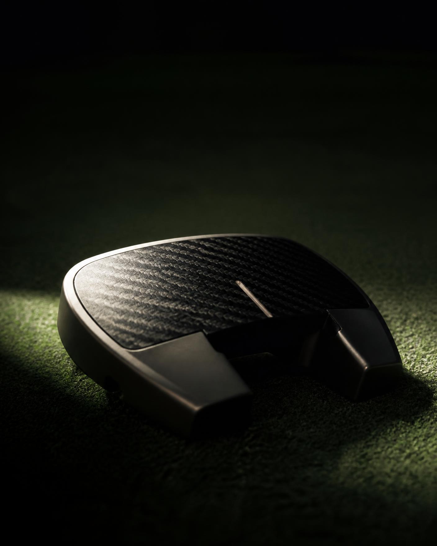 High-MOI putter head on a dark green with nothing attached to the club